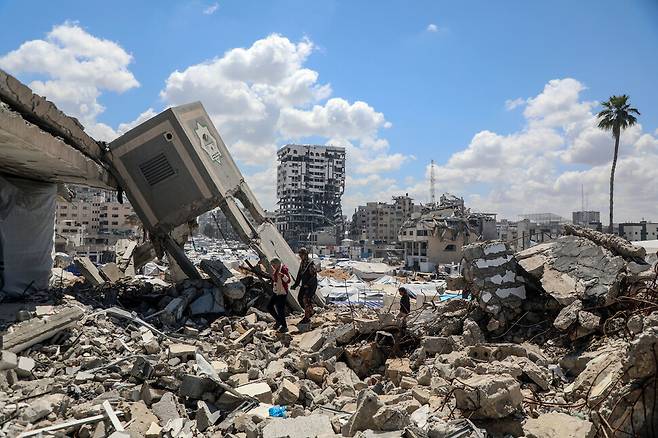 17일(현지시각) 가자지구 가자시티의 무너진 건물 잔해 사이를 한 남성이 걷고 있다. 가자시티/신화 연합뉴스