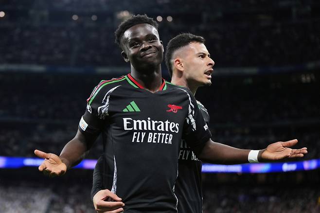 <yonhap photo-2536=""> Arsenal's Bukayo Saka celebrates with Gabriel Martinelli, right, after scoring the opening goal during the Champions League quarterfinals second leg soccer match between Real Madrid and Arsenal at the Santiago Bernabeu stadium in Madrid, Wednesday, April 16, 2025. (AP Photo/Manu Fernandez)/2025-04-17 07:10:19/ <저작권자 ⓒ 1980-2025 ㈜연합뉴스. 무단 전재 재배포 금지, AI 학습 및 활용 금지></yonhap>