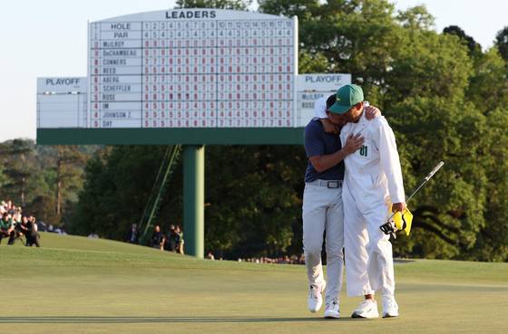 매킬로이(왼쪽)는 14일 마스터스 우승 후 캐디 해리 다이아몬드와 뜨거운 포옹을 나눴다. [로이터=연합뉴스]