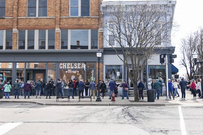 미국 미시간주 작은 마을 첼시의 동네 책방 세렌디피티북스(Serendipity Books)의 지난 13일 이삿날 봉사자들이 인간띠를 만들어 한 블록 떨어진 새 매장으로 이사를 돕는 장면. AP 연합뉴스