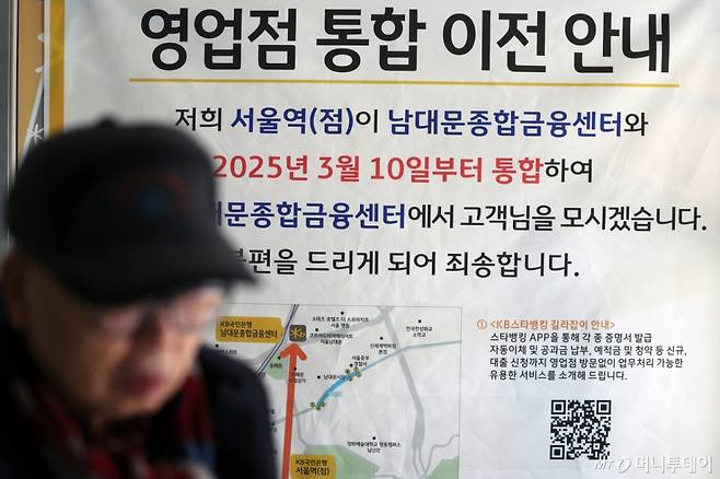 (서울=뉴스1) 황기선 기자 = 11일 서울 중구 KB국민은행 서울역점에 영업점 통합 이전 안내문이 붙어있다.  금융권에 따르면 5대 은행(KB국민·신한·하나·우리·NH농협)들의 총영업점 수는 2023년 말 3927개에서 지난 9일 기준 3790개로 약 1년 1개월 새 137개가 줄었다.   은행권은 온라인 비대면 금융 확산과 경영 효율 등을 이유로 내세우고 있지만 모바일과 인터넷 서비스에 익숙하지 않은 고령층의 금융 접근성이 갈수록 떨어지는 문제가 제기되고 있다. 2025.2.11/뉴스1  Copyright (C) 뉴스1. All rights reserved. 무단 전재 및 재배포,  AI학습 이용 금지. /사진=(서울=뉴스1) 황기선 기자