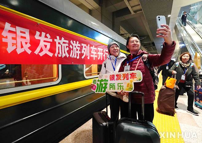 [베이징=신화/뉴시스] 트럼프 행정부의 관세 충격을 상쇄하기 위해 소비 진작을 최우선 과제로 정한 중국이 경제적, 시간적 여유가 있는 고령자의 소비를 끌어내는데 총력을 기울이고 있다. 사진은 지난 3월15일 베이징 기차역에서 실버열차 관광에 참여자들이 셀카를 찍는 모습. 2025.04.17