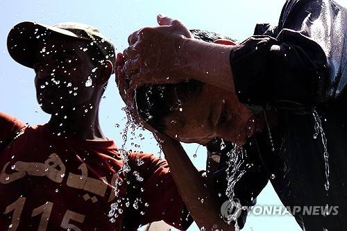 파키스탄 폭염 폭염이 계속되자 지난 5일 파키스탄 카라치에서 한 남성이 머리에 물을 뿌리며 더위를 식히고 있다. [EPA 연합뉴스 자료사진. 재판매 및 DB 금지]