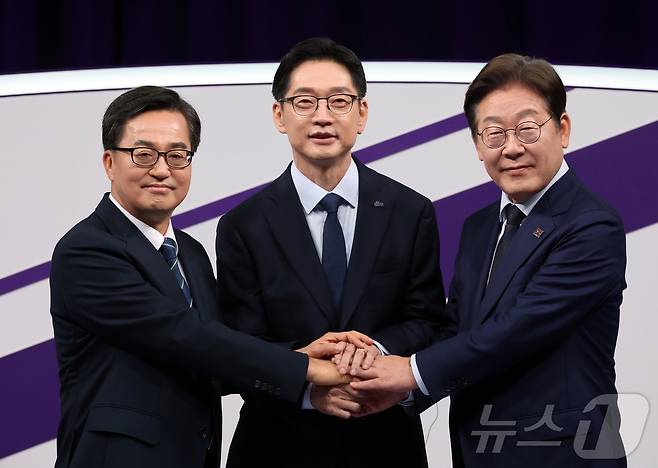 18일 저녁 상암MBC 스튜디오에서 열린 더불어민주당 대선 경선 후보자 첫 TV토론에 참석한 (오른쪽부터) 이재명, 김경수, 김동연 후보자가 손을 맞잡고 있다. 2025.4.18/뉴스1 ⓒ News1 국회사진취재단