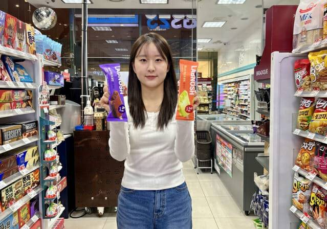 모델이 GS25에서 랩노쉬 저당 프로틴바 2종을 들고 포즈를 취하고 있다. (제공=GS리테일)