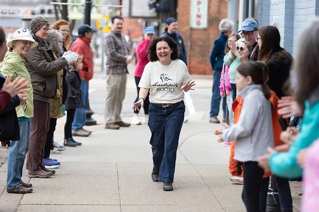 책방 주인 미셸 투플린이 2시간도 채 안 돼 책방 이사를 마친 뒤 도와준 주민들 사이를 지나며 활짝 웃고 있다.