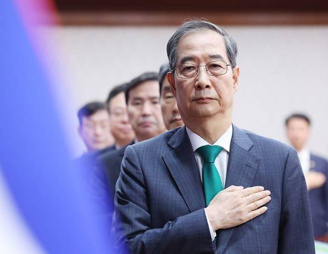 한덕수 대통령 권한대행 국무총리가 18일 정부서울청사에서 추가경정예산안 심의 임시국무회의에서 국기에 경례하고 있다. ⓒ뉴시스