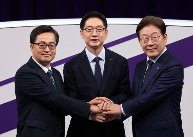 18일 상암MBC 스튜디오에서 열린 더불어민주당 대선 경선 후보자 첫 TV토론에 참석한 (오른쪽부터)이재명, 김경수, 김동연 후보자가 손을 맞잡고 있다.뉴스1