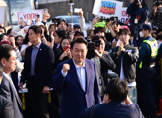 윤석열 전 대통령이 11일 오후 서울 용산구 한남동 관저 정문에서 퇴거하며 지지자들에게 인사하고 있다. 윤 전 대통령 뒤편에 'YOON AGAIN'(윤 어게인)이라고 적힌 팻말이 보인다. 전민규 기자