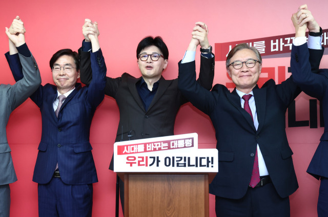 ▲국민의힘 한동훈 대선 경선 후보가 18일 서울 여의도 선거 사무소에서 열린 캠프 인선 등 현안 관련 기자회견에서 최재형(오른쪽), 조경태 공동선대위원장과 손을 맞잡고 기념촬영을 하고 있다. ⓒ연합뉴스