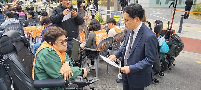 18일 ‘울산 태연재활원 인권참사 희생자 추모제’에 참가한 장애인이 손호준 보건복지부 장애인정책국장에게&nbsp;‘조규홍 복지부 장관 면담 요청서’를 전달하고 있다.&nbsp;&nbsp;전장연 제공