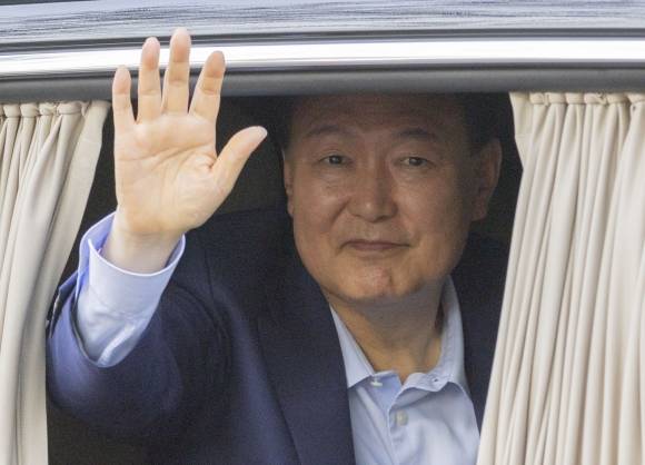 윤석열 전 대통령이 11일 한남동 관저를 떠나 사저가 있는 서초구 아크로비스타에 도착하며 지지자들을 향해 손 인사를 하고 있다. 연합뉴스