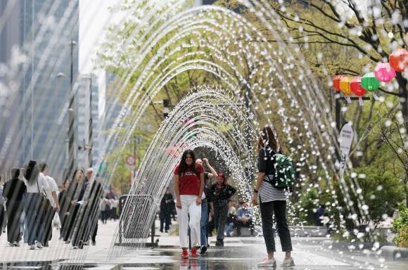 벌써 여름? - 17일 오후 서울 종로구 광화문광장에서 외국인 관광객들이 반팔 티셔츠를 입은 채 분수 터널을 통과하고 있다. 기상청은 당분간 따뜻하지만, 일교차가 큰 봄 날씨가 이어질 것으로 내다보고 있다.  뉴스1