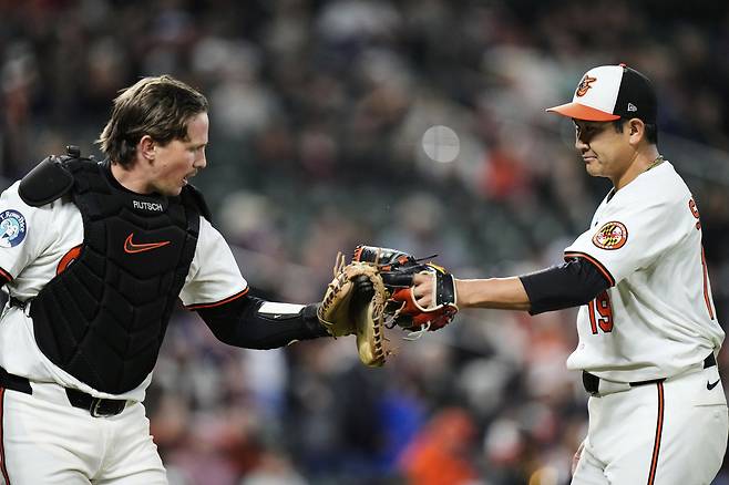 볼티모어 스가노가 18일 클리블랜드전에서 7이닝을 마친 뒤 포수 애들리 러치맨과 글러브를 맞대고 있다. AP연합뉴스