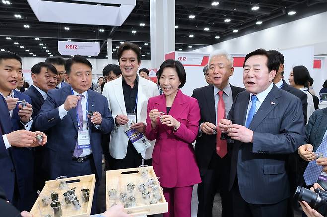 기업전시회를 둘러보는 주요 인사들 미국 애틀랜타에서 열린 세계한인비즈니스대회의 주요 프로그램인 기업전시회 개막 후 중소기업 제품 전시 부스에서 시식을 해보는 주요 인사들. 우측부터 김기문 중소기업중앙회장, 이상덕 동포청장, 오영주 중소벤처기업부 장관, 배우 정준호, 김영환 충북도지사. [동포청 제공. 재판매 및 DB 금지]
