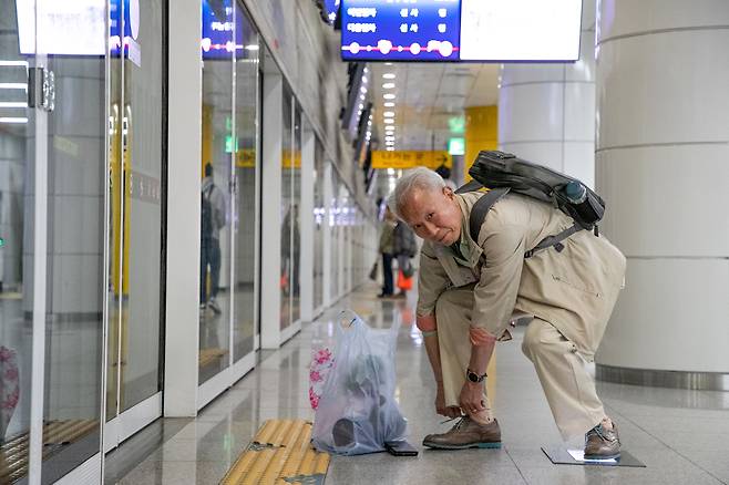 18일 오전 서울 서초구 신분당선 청계산입구역에서 실버 택배원 최영식씨가 신발끈을 고쳐 매고 있다. 이날 최씨는 청계산 화훼단지에서 개원 축하 선물인 대나무 화분을 받아 서울 성동구의 한 개인 병원에 배달했다. 최씨는 “사람이 좋아서 일을 안 할 수가 없다”며 “사무실에서 사람들과 대화하는 것도 낙이고, 지하철에서 사람 구경하며 살맛 난다”고 했다./장련성 기자