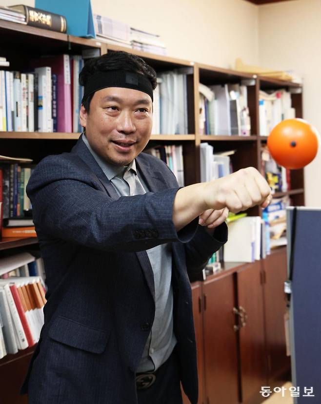 박정진 경남대 서울캠퍼스 부총장이 서울 종로구 경남대 극동문제연구소 연구실에서 머리 밴드에 연결된 펀치볼에 주먹을 날리고 있다. 이훈구 기자 ufo@donga.com