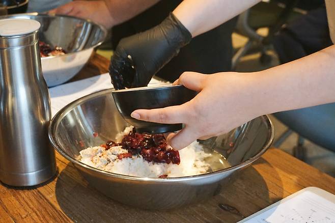 A student blends cherries with makgeolli ingredients to create a cherry-flavored drink during a hands-on brewing class at Jasaeng-jeonsul, a traditional alcohol workshop in Suwon, Gyeonggi Province. (Jasaeng-jeonsul)