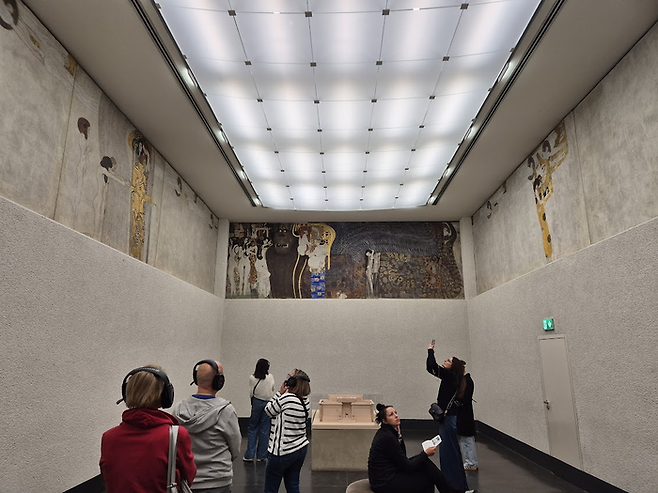 베토벤의 합창을 들으며 베토벤 프리즈를 보고 있는 관람객들. ©김슬기