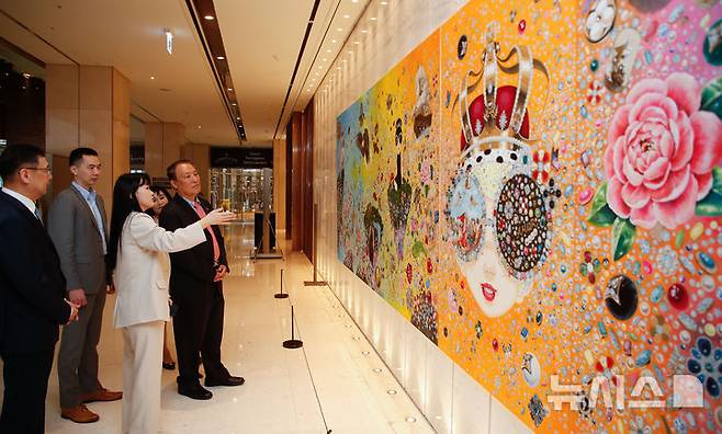 [서귀포=뉴시스] 우장호 기자 = 제주신화월드 메리어트 리조트 1층에 '더 갤러리(THE GALLERY)'가 정식 개관했다. 더 갤러리의 첫 전시는 '인투 더 아일랜드(INTO THE ISLAND)'라는 주제로 김지희 작가의 개인전으로 꾸며졌다. 김 작가가 19일 오후 더 갤러리 개관식에서 양영철 제주국제자유도시개발센터 이사장 등 내빈들에게 작품을 설명하고 있다. 김 작가는 현대인의 욕망과 존재에 대한 날카로운 통찰을 시각 언어로 풀어냈다. 이번 전시에서는 10m 규모 대형 회화 작품을 포함한 주요 작품들을 공개했다. 2025.04.19. woo1223@newsis.com