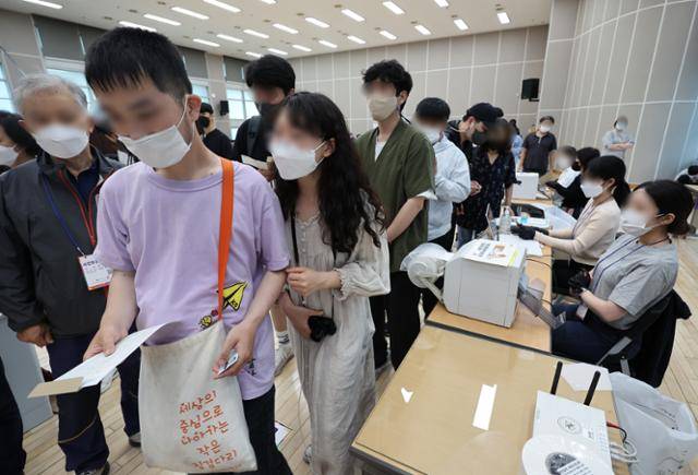 2022년 5월 27일 지방선거 사전투표 첫날 서울 용산구 원효로제1동 주민센터에서 발달장애인들이 가족의 도움을 받아 소중한 한 표를 행사하고 있다. 연합뉴스