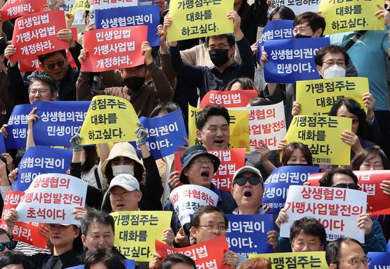 가맹점주들이 지난해 5월 9일 서울 여의도 국회 본관 앞 계단에서 열린 가맹점주 상생협의권 처리 촉구 기자회견에서 구호를 외치고 있다. 뉴스1