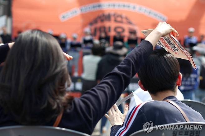 우리 주변, 누군가에겐 소중한 사람 2024년 4월 19일 서울시청 인근에서 열린 23회 420장애인차별철폐투쟁 전국결의대회에서 한 어머니가 발달장애인 아들에게 오는 햇빛을 막아주고 있다. [연합뉴스 자료사진]