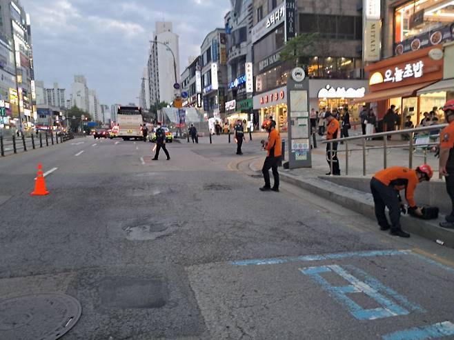 21일 용인시 수지구 신분당선 수지구청역 인근 도로에서 땅 꺼짐 현상이 발생해 소방대원 등이 도로를 통제하고 있다. 사진=경기도소방재난본부