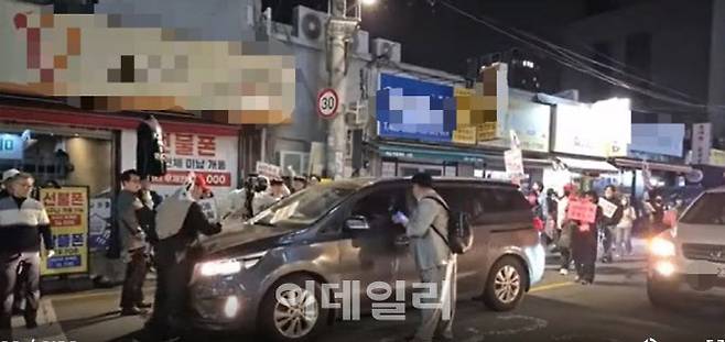 지난 17일 오후 10시 20분쯤 서울 광진구 양꼬치거리 골목에서 윤석열 전 대통령 지지단체 측이 행진을 벌이는 가운데 한 차량과 마찰을 빚고 있다. (사진=유튜브 채널 갈무리)