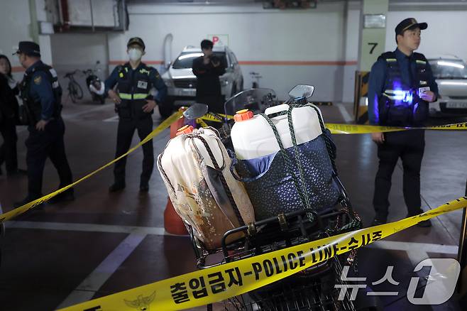 21일 서울 관악구 봉천동의 한 아파트에서 화재가 발생, 경찰 과학수사대가 지하 주차장에서 주민 신고로 기름통이 실린 오토바이를 조사하고 있다. 2025.4.21/뉴스1 ⓒ News1 박정호 기자