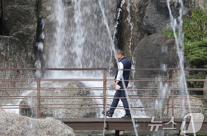 낮 최고기온이 26도까지 오르는 등 따뜻한 초여름 날씨를 보인 21일 경기 안산시 상록구 노적봉인공폭포공원을 찾은 시민이 시원한 폭포를 바라보고 있다. 2025.4.21/뉴스1 ⓒ News1 김영운 기자