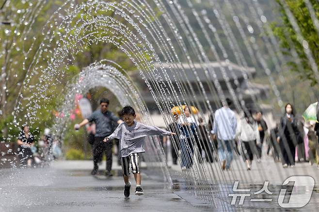 서울 낮 최고기온이 26도를 기록하는 등 초여름 날씨를 보인 21일 서울 세종대로 광화문광장 터널 분수에서 어린이가 더위를 식히고 있다. 2025.4.21/뉴스1 ⓒ News1 이승배 기자
