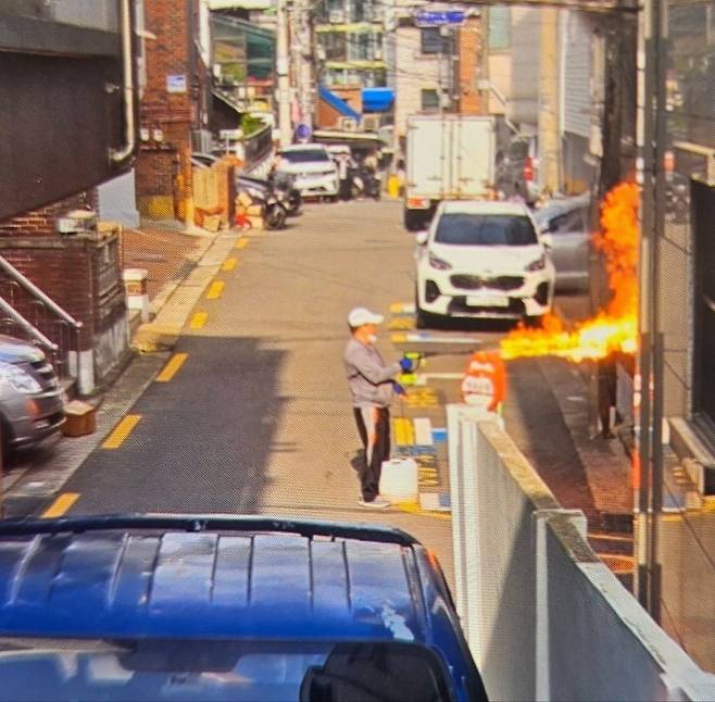 21일 오전 서울 관악구에서 60대 남성이 농약살포기로 주택에 불을 지르고 있다. 이 남성은 인근 아파트에도 불을 지르다 아파트 복도에서 사망한 채 발견됐다. /온라인 커뮤니티