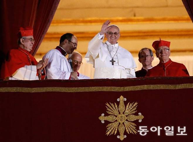 2013년 3월 새 교황에 선출된 프란치스코 교황(가운데)이 성 베드로 대성당의 발코니에 나와 신자들을 향해 손을 흔들고 있다. 교황은 “다른 사람을 위해, 세계를 위해, 나를 위해 기도해 달라”고 말했다. 바티칸=EPA 연합뉴스 동아일보 DB