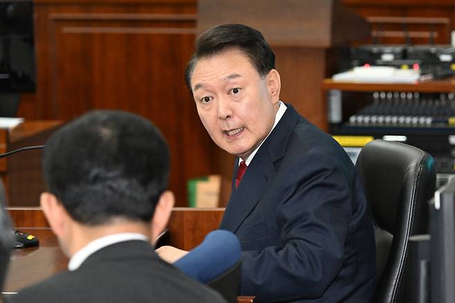 윤석열 전 대통령이 21일 오전 서울 서초구 서울중앙지법에서 열린 내란 우두머리 혐의 형사 재판 2차 공판에 출석해 변호인과 이야기하고 있다. 사진공동취재단