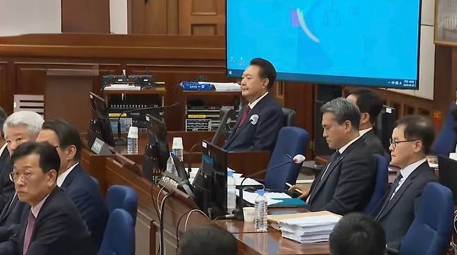 윤석열 전 대통령이 21일 서초동 서울중앙지법에서 열린 내란 우두머리 혐의에 대한 두 번째 정식 재판에 출석해 변호인단과 함께 자리에 앉아있다. (SBS 캡처)