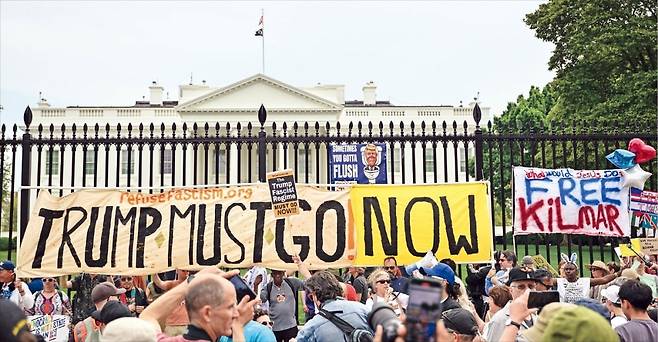 < 격해지는 反트럼프 시위 > 미국 백악관 앞에서 19일(현지시간) ﻿시위대가 ‘트럼프 물러나라’는 팻말을 들고 있다. 미국 독립전쟁 발발 250주년인 이날 미국 전역에서는 반﻿트럼프 시위 1200건이 열렸다.  AFP연합뉴스