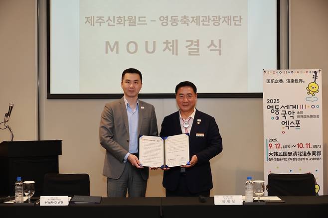 정영철 충북 영동군수(오른쪽)와 국내 최대 복합리조트인 제주신화월드가 축제·관광 콘텐츠 공동 마케팅과 교류 확대를 위한 업무협약을 하고 기념사진을 찍고 있다. 영동군 제공.