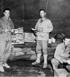 미군 병사들이 서태평양 이오지마 텐트 도서관에서 책을 살펴보고 있다. Grolier Club