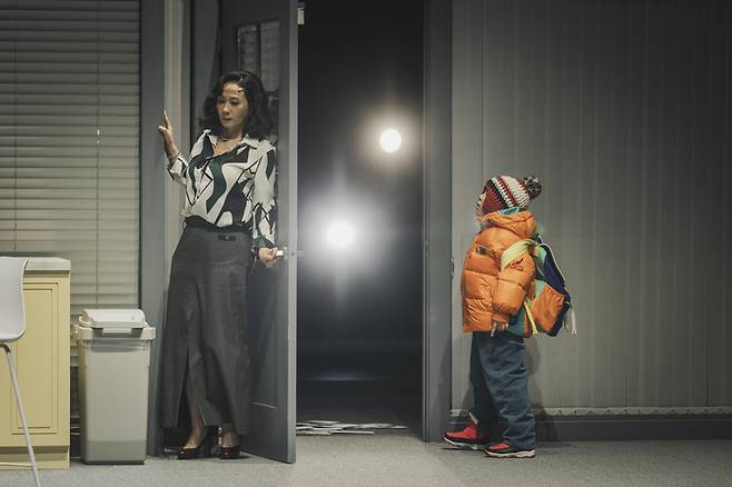 연극 ‘그의 어머니’에서 브렌다(김선영)와 둘째 아들 제이슨(최자운)이 언론의 스포트라이트 속 집 밖을 나서고 있다. <국립극단>