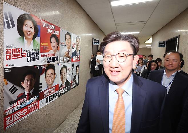 권성동 국민의힘 원내대표가 21일 서울 여의도 국회에서 열린 비상대책위원회의에 참석하면서 대선 경선 후보자들의 포스터가 붙어 있는 벽 앞을 지나가고 있다.  연합뉴스
