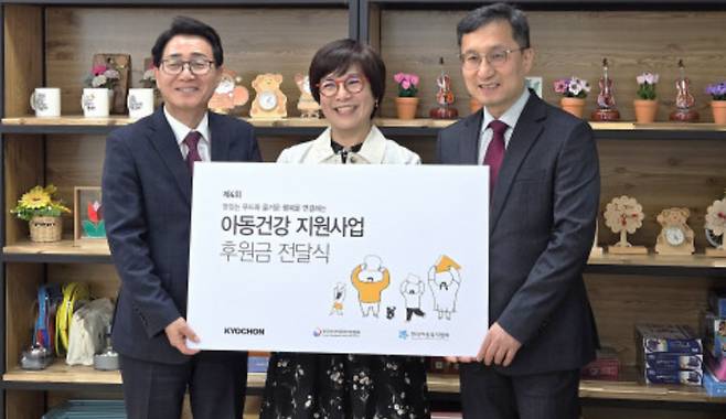 강창동 교촌에프앤비 커뮤니케이션부문장(왼쪽)이 옥경원 한국지역아동센터연합회 대표(가운데)에게  ‘제4회 아동건강 지원사업' 후원금을 전달했다. /사진제공=한국지역아동센터