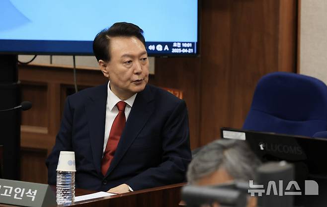 [서울=뉴시스] 사진공동취재단 = 12·3 비상계엄을 선포해 내란 우두머리 혐의로 재판에 넘겨진 윤석열 전 대통령이 21일 오전 서울 서초구 서울중앙지법 417호 법정에 앉아 변호인단과 대화를 하고 있다. 2025.04.21. photo@newsis.com