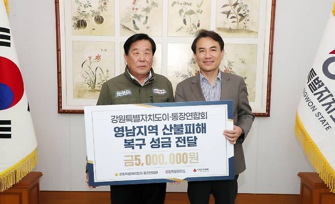 전영록 강원도이통장연합회장(왼쪽)이 18일 김진태 강원도지사에게 영남 산불 이재민 돕기 성금을 전달했다. 연합뉴스