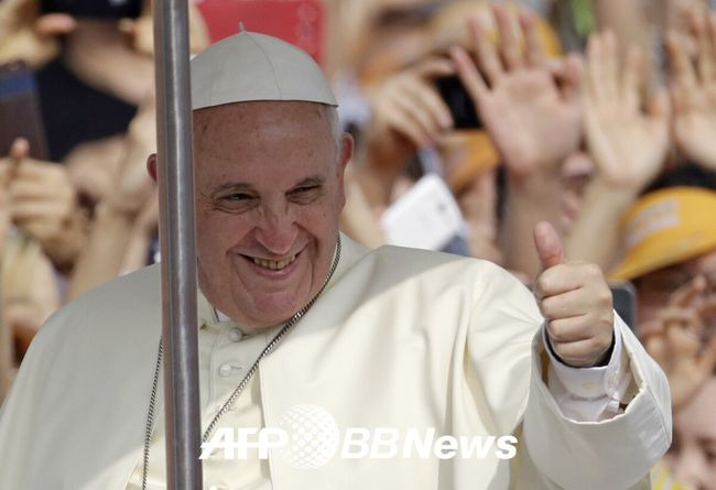 Pope Francis gestures towards Catholic worshippers as he arrives to lead a mass at Gwanghwamun Square in central Seoul on August 16, 2014. Pope Francis beatified 124 early Korean martyrs August 16 at a mass in Seoul and challenged the massive crowd to ask what values they might be willing to die for in an increasingly materialistic, globalised world. AFP PHOTO / POOL / Lee Jin-man