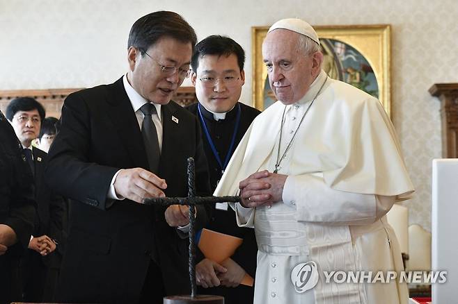 (바티칸=연합뉴스) 2021년 10월 29일(현지시간) 교황청을 공식 방문한 문재인 당시 대통령이 프란치스코 교황과 단독 면담에 앞서 DMZ 철조망을 잘라 만든 평화의 십자가에 대해 설명하고 있다. [교황청 제공=자료사진]