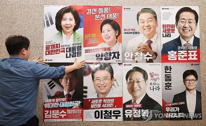 국민의힘 대선 경선 후보자는 누가될까? (서울=연합뉴스) 김주형 기자 = 20일 서울 여의도 국회 본청 국민의힘 사무실 앞에 당 관계자가 대선 경선 후보자 포스터를 붙이고 있다. 2025.4.20 kjhpress@yna.co.kr
