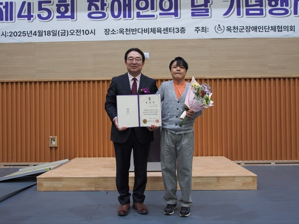 ▲ 김창규(오른쪽) 씨가 제45회 장애인의 날 행사에서 충북도지사표창을 받은 후 황규철 옥천군수와 기념찰영을 하고 있다. 옥천군 제공