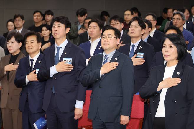 22일 서울 여의도 국회 의원회관에서 열린 더불어민주당 방송·콘텐츠특별위원회 출범식에서 박찬대 당대표 직무대행 겸 원내대표(아랫줄 오른쪽에서 두 번째), 최민희 과학기술정보방송통신위원장(아랫줄 가장 오른쪽) 등 참석자들이 국기에 경례하고 있다.(사진=연합뉴스)