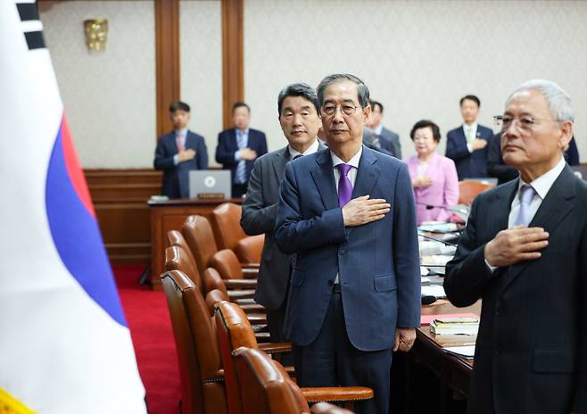 한덕수 대통령 권한대행 국무총리가 22일 서울 종로구 정부서울청사에서 열린 국무회의에서 국기에 경례를 하고 있다. /뉴시스